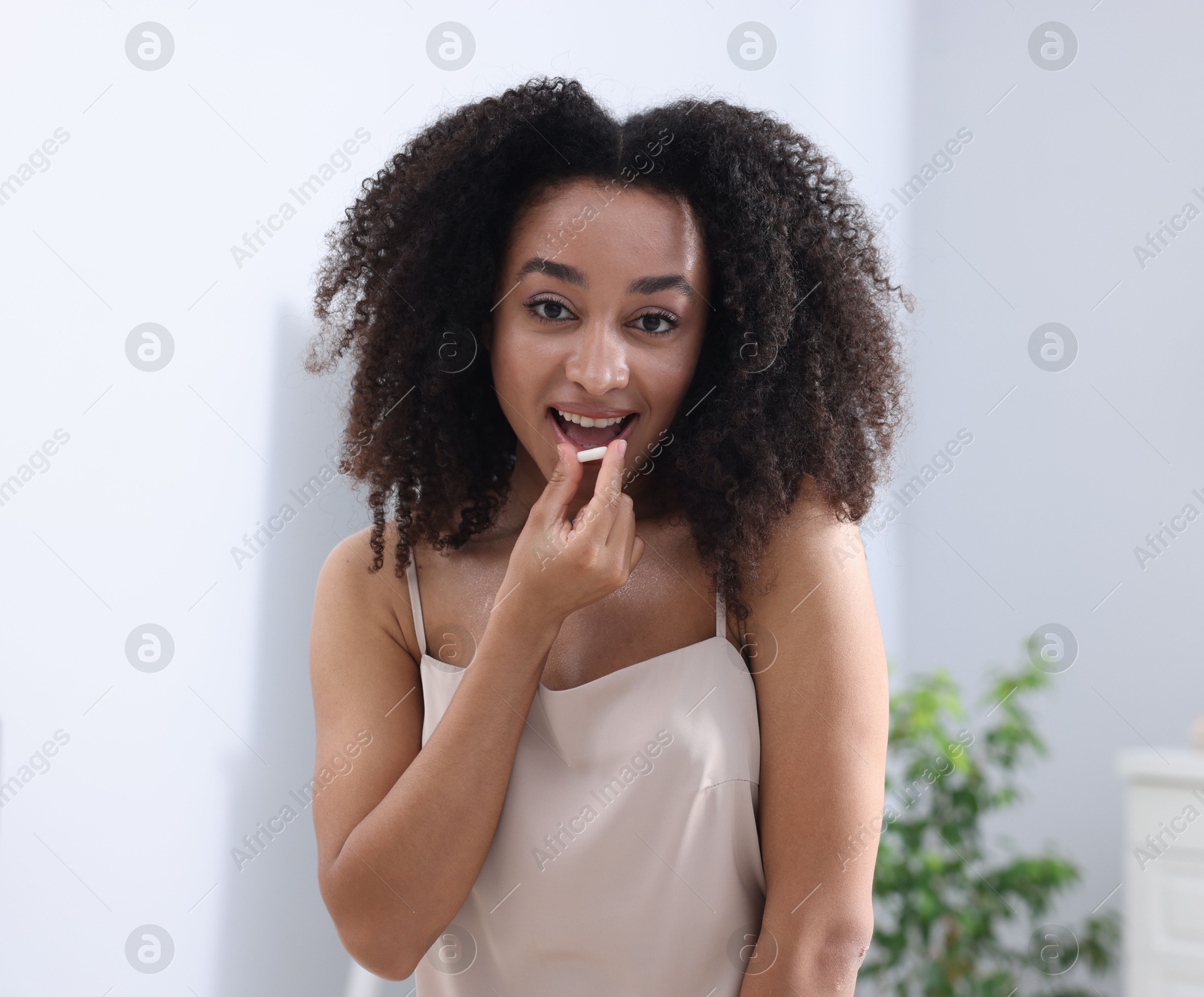 Beautiful Brazilian woman with collagen pill indoors Photo of Beautiful Brazilian woman with collagen pill indoors