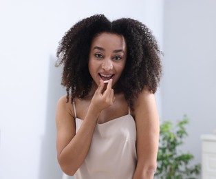 Photo of Beautiful Brazilian woman with collagen pill indoors