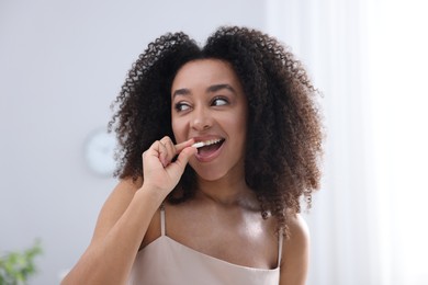 Photo of Beautiful Brazilian woman with collagen pill indoors