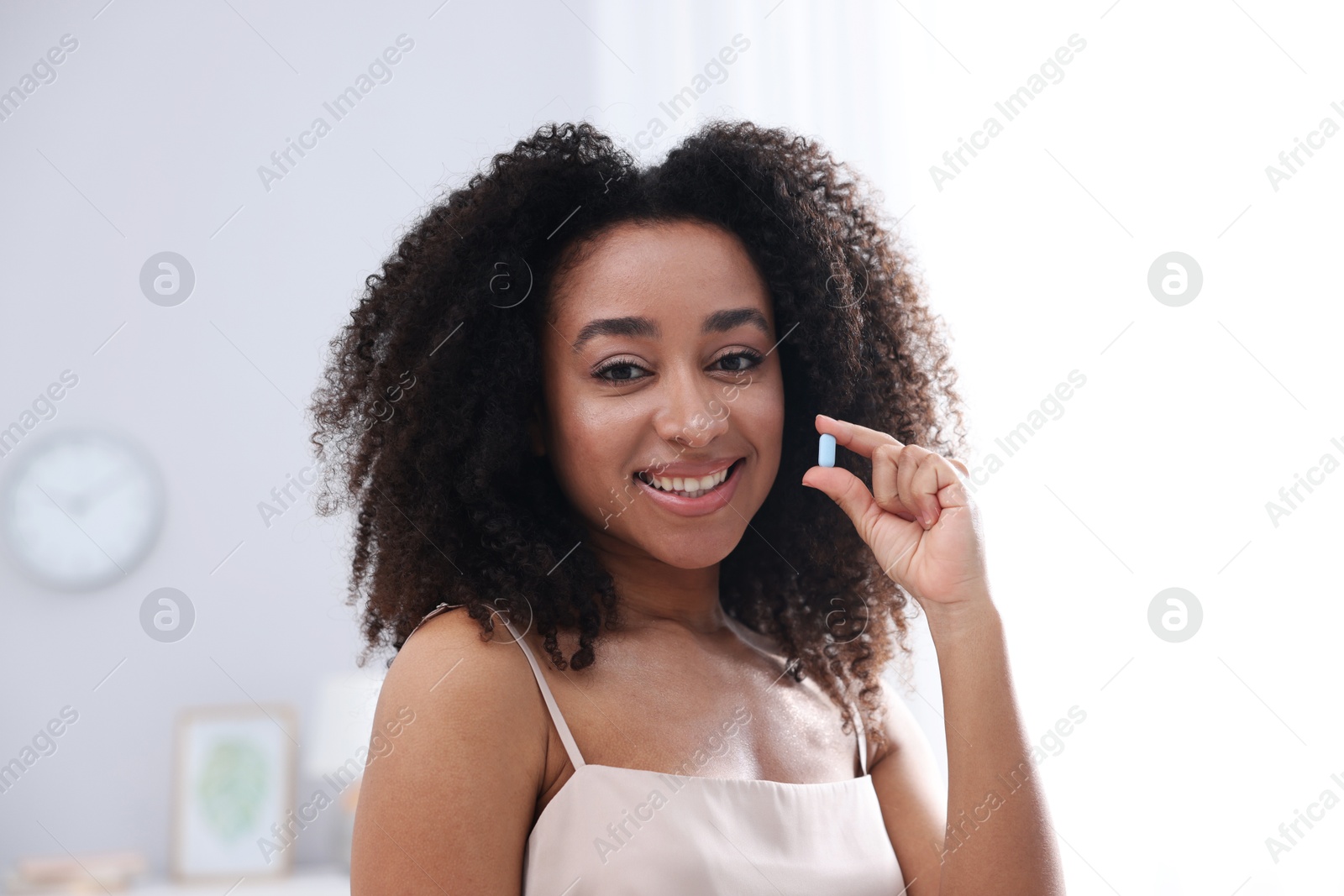 Beautiful Brazilian woman with collagen pill indoors Photo of Beautiful Brazilian woman with collagen pill indoors