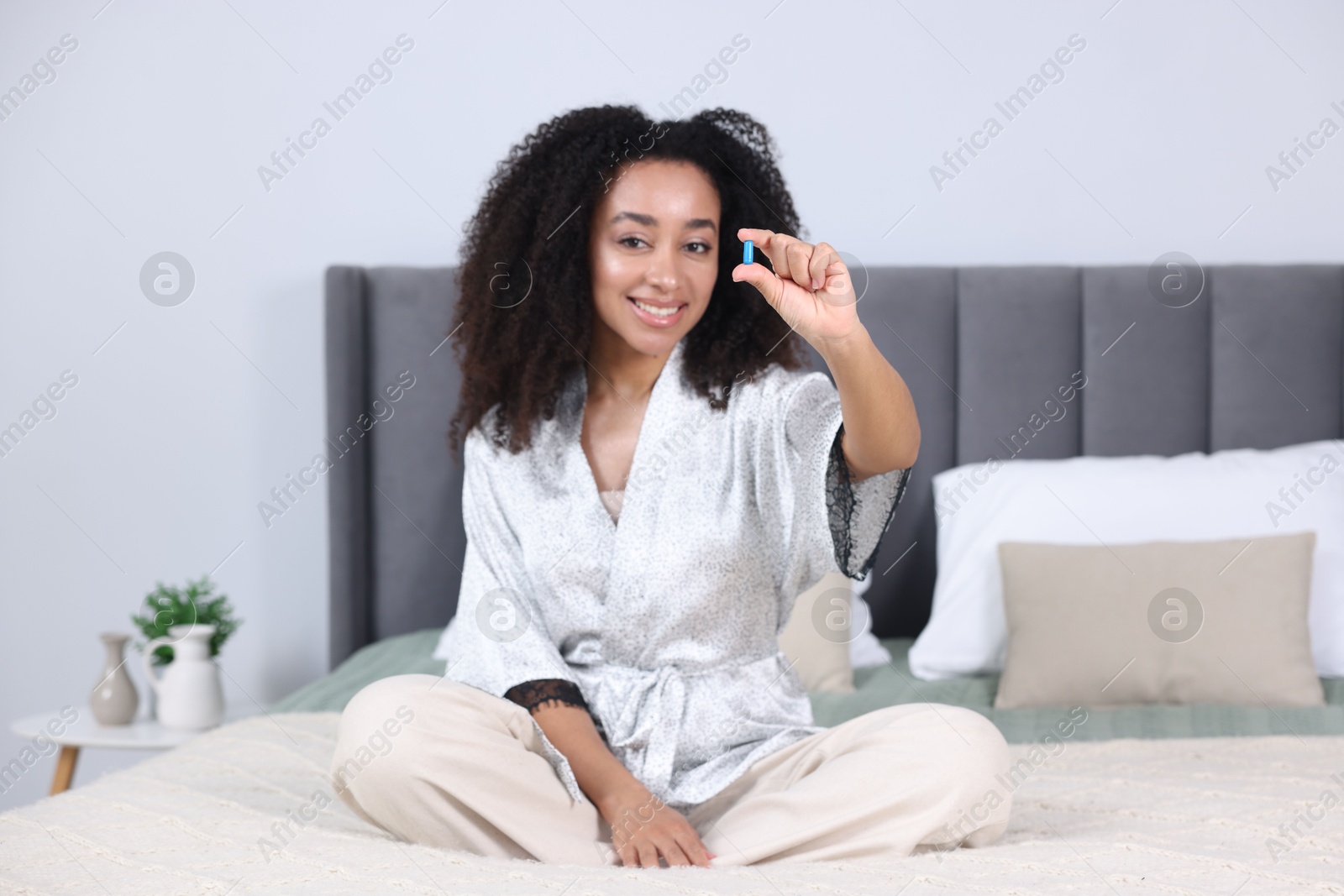 Beautiful Brazilian woman with collagen pill indoors Photo of Beautiful Brazilian woman with collagen pill indoors