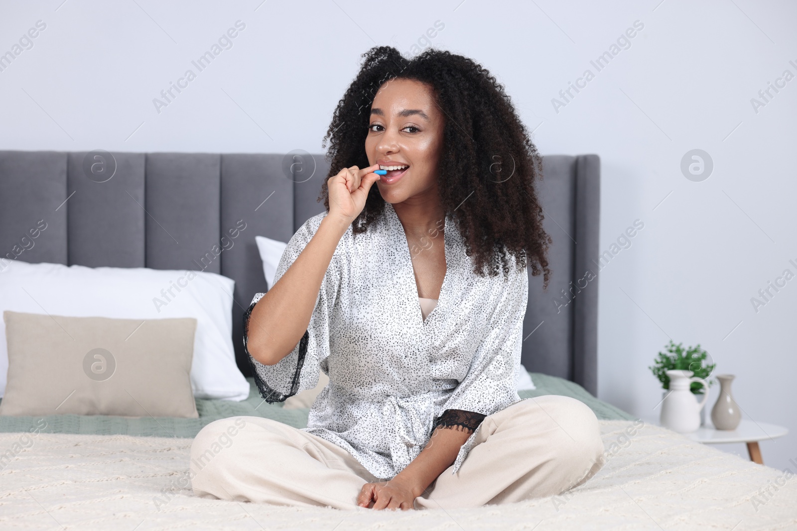 Beautiful Brazilian woman taking collagen pill indoors Photo of Beautiful Brazilian woman taking collagen pill indoors