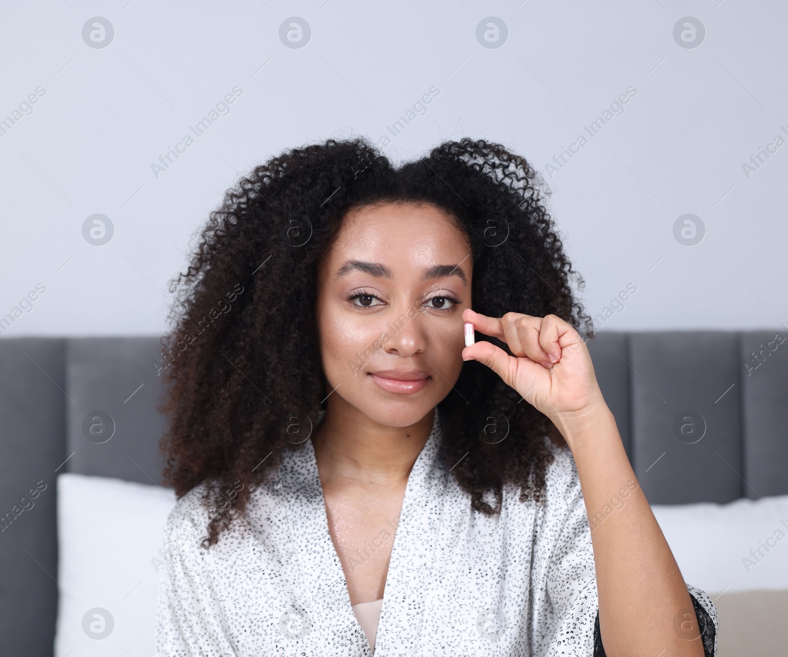 Beautiful Brazilian woman with collagen pill indoors Photo of Beautiful Brazilian woman with collagen pill indoors