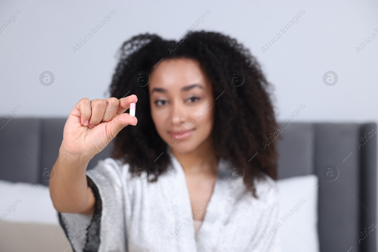 Beautiful Brazilian woman with collagen pill indoors, selective focus Photo of Beautiful Brazilian woman with collagen pill indoors, selective focus