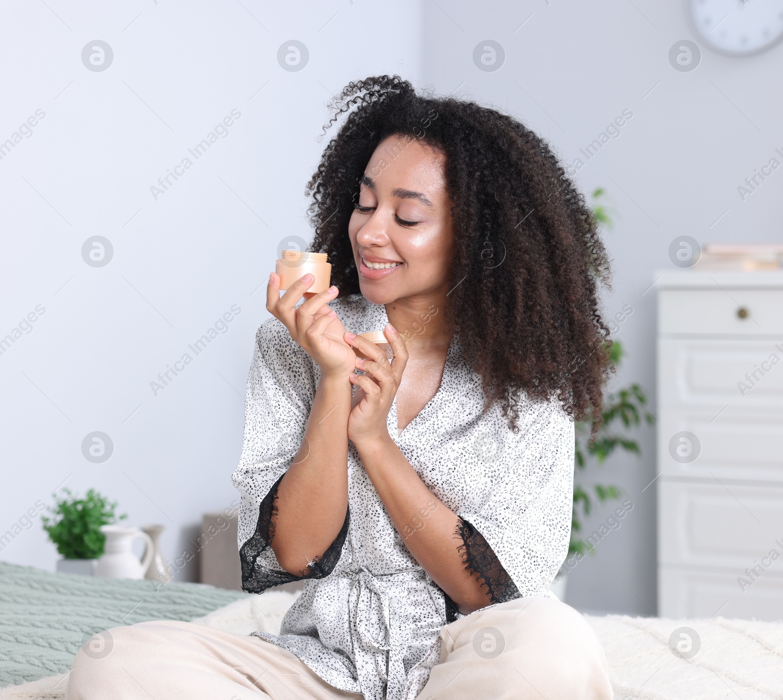 Beautiful Brazilian woman with jar of collagen cream indoors Photo of Beautiful Brazilian woman with jar of collagen cream indoors