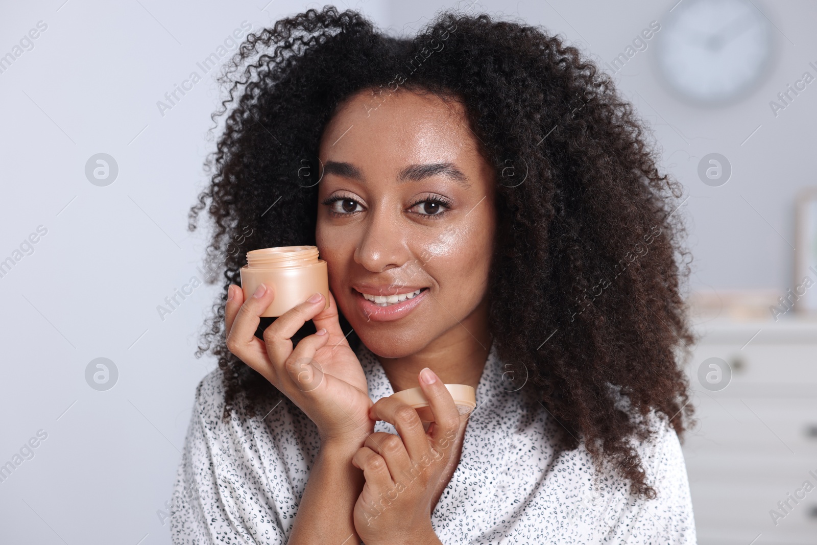 Beautiful Brazilian woman with jar of collagen cream indoors Photo of Beautiful Brazilian woman with jar of collagen cream indoors