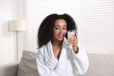 Photo of Beautiful Brazilian woman with glass of collagen water indoors