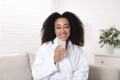 Photo of Beautiful Brazilian woman with glass of collagen water indoors