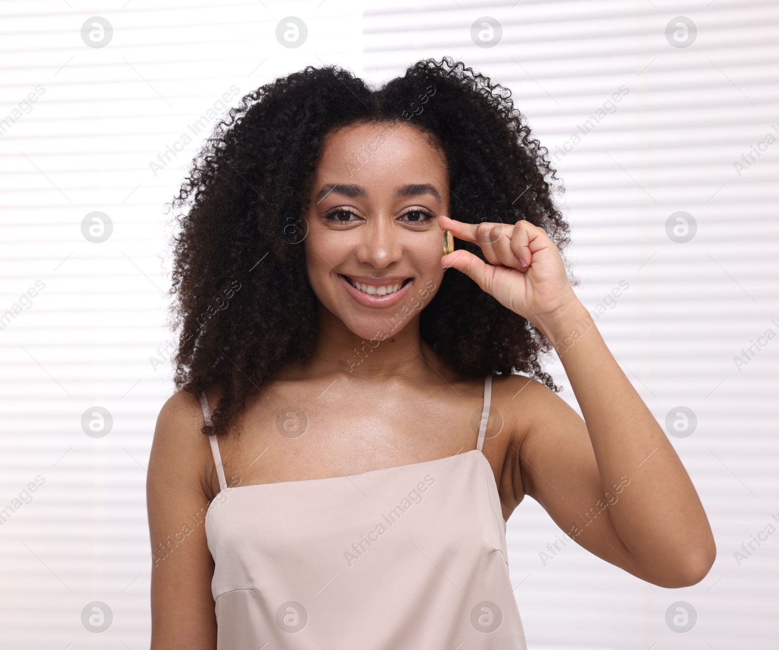 Beautiful Brazilian woman with collagen pill indoors Photo of Beautiful Brazilian woman with collagen pill indoors
