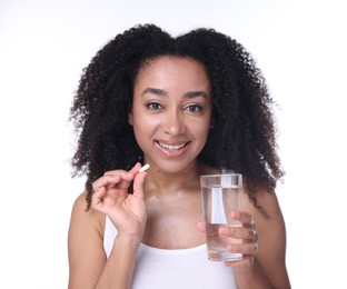 Photo of Beautiful Brazilian woman with glass of water and collagen pill on white background
