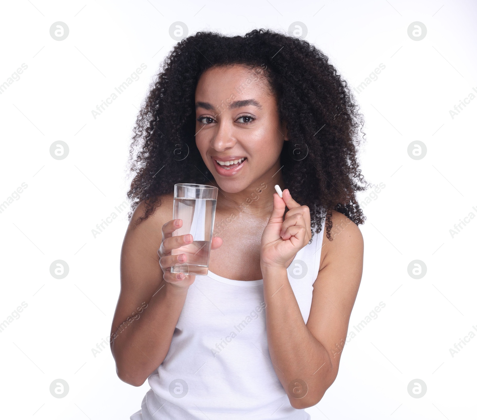 Beautiful Brazilian woman with glass of water and collagen pill on white background Photo of Beautiful Brazilian woman with glass of water and collagen pill on white background
