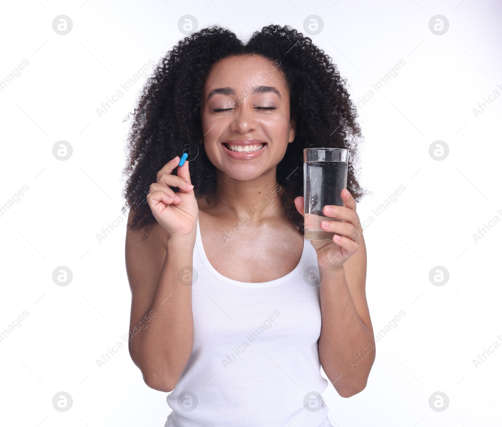 Beautiful Brazilian woman with glass of water and collagen pill on white background Photo of Beautiful Brazilian woman with glass of water and collagen pill on white background