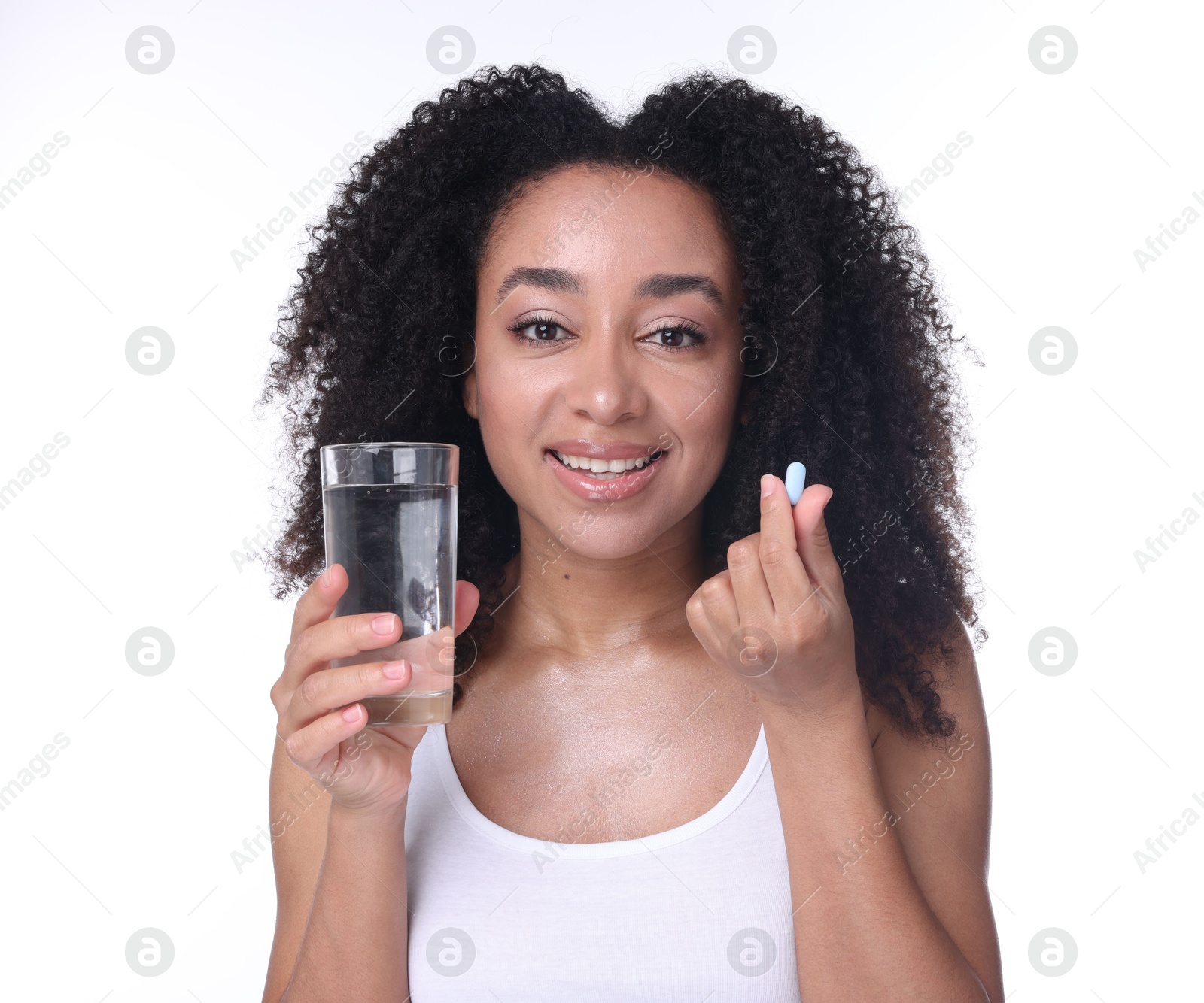 Beautiful Brazilian woman with glass of water and collagen pill on white background Photo of Beautiful Brazilian woman with glass of water and collagen pill on white background