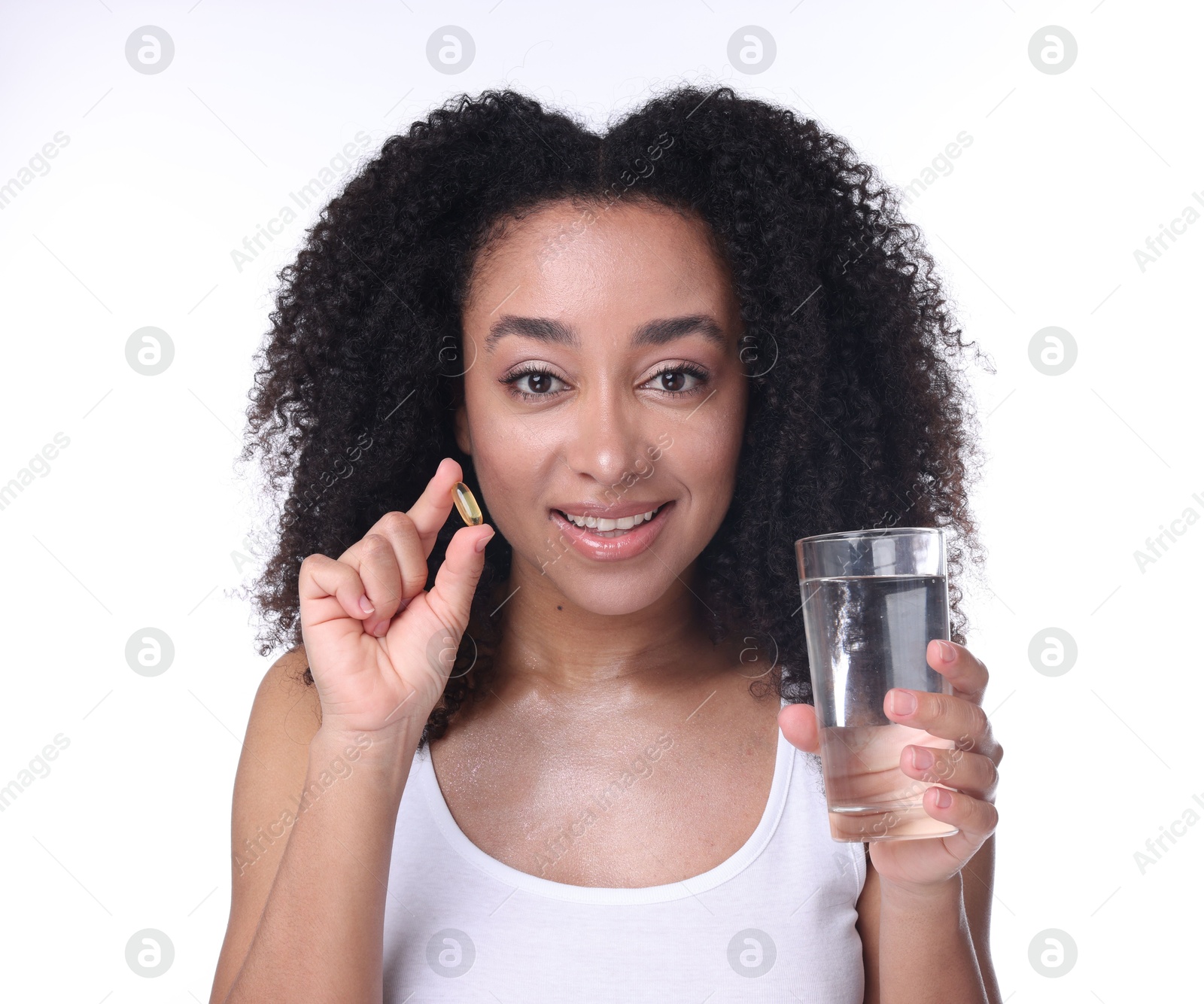 Beautiful Brazilian woman with glass of water and collagen pill on white background Photo of Beautiful Brazilian woman with glass of water and collagen pill on white background