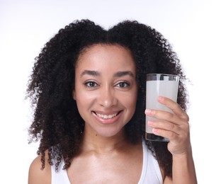 Photo of Beautiful Brazilian woman with glass of collagen water on white background