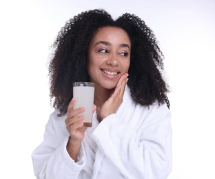Photo of Beautiful Brazilian woman with glass of collagen water on white background