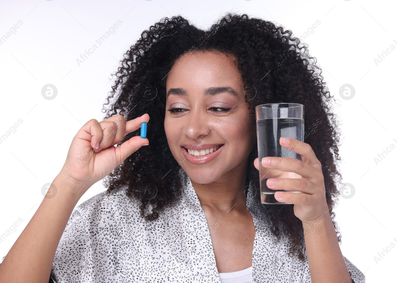 Beautiful Brazilian woman with glass of water and collagen pill on white background Photo of Beautiful Brazilian woman with glass of water and collagen pill on white background
