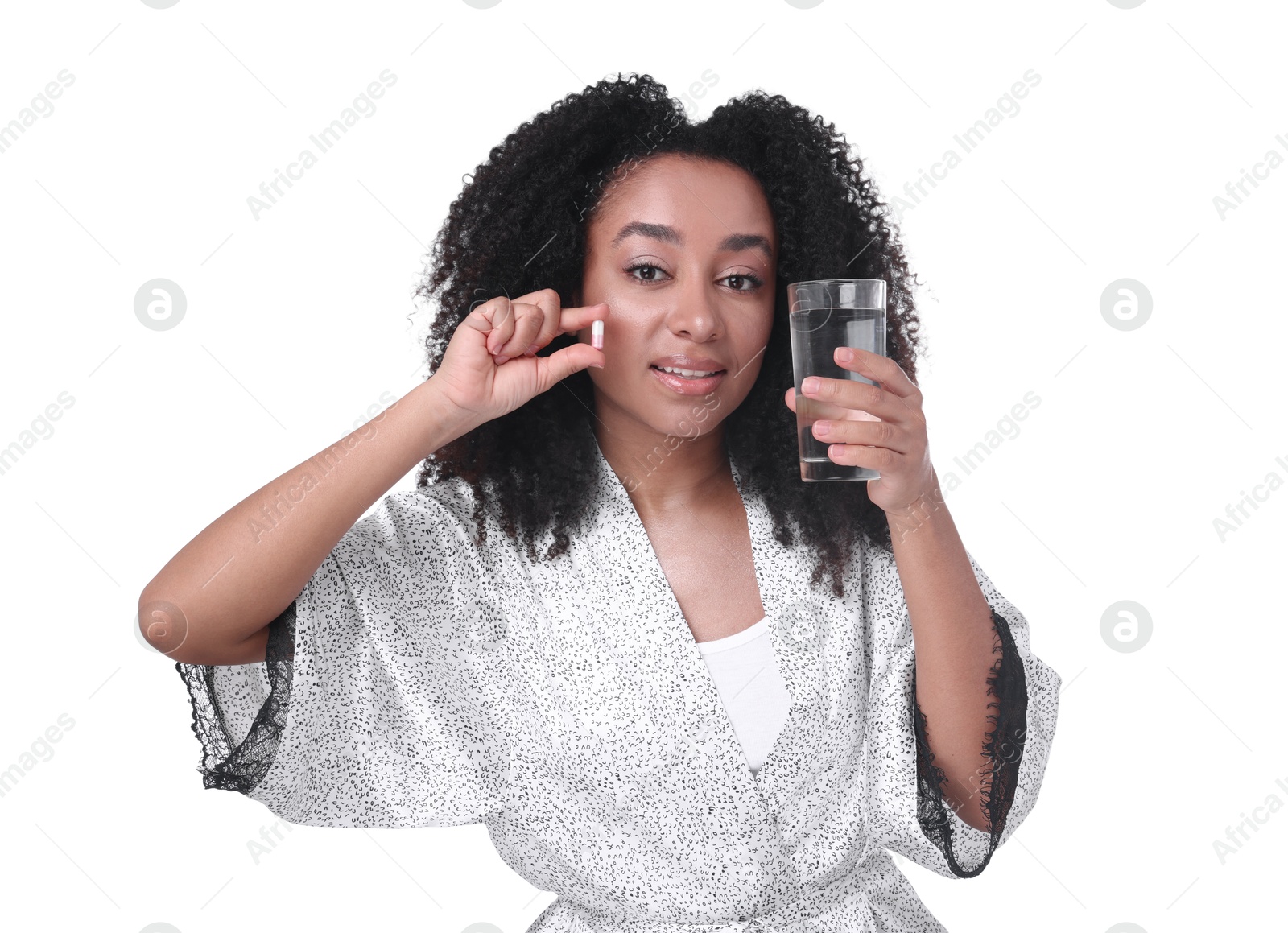 Beautiful Brazilian woman with glass of water and collagen pill on white background Photo of Beautiful Brazilian woman with glass of water and collagen pill on white background