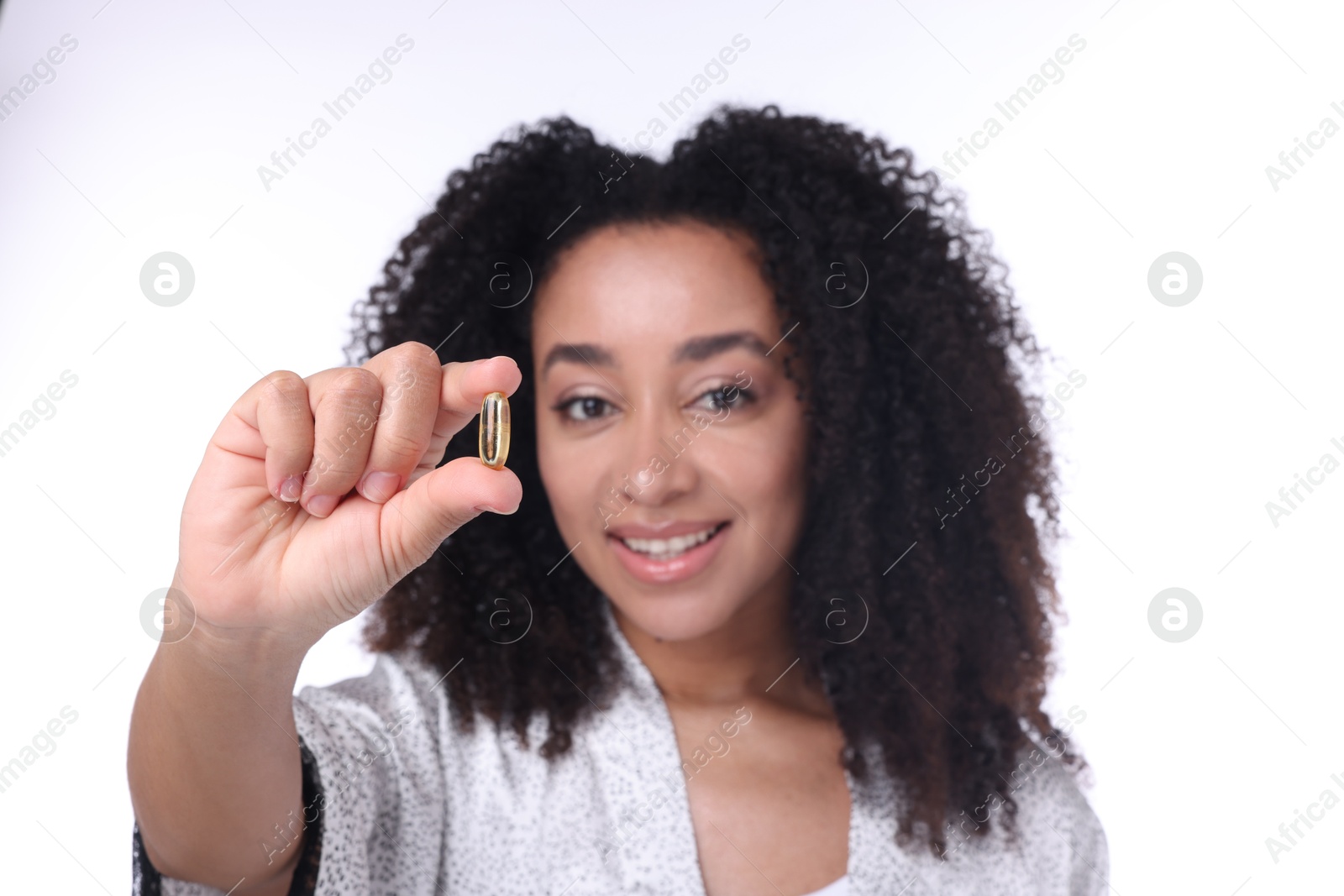 Beautiful Brazilian woman with collagen pill on white background, selective focus Photo of Beautiful Brazilian woman with collagen pill on white background, selective focus