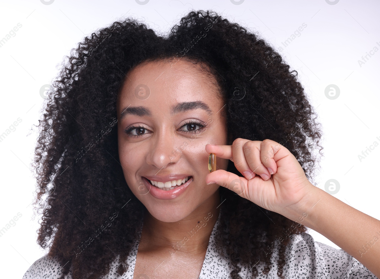 Beautiful Brazilian woman with collagen pill on white background, closeup Photo of Beautiful Brazilian woman with collagen pill on white background, closeup