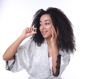 Photo of Beautiful Brazilian woman with collagen pill on white background