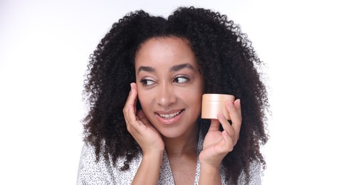 Photo of Beautiful Brazilian woman with jar of collagen cream on white background