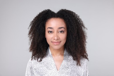 Photo of Beautiful Brazilian woman with healthy skin on gray background