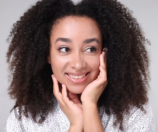Photo of Beautiful Brazilian woman with healthy skin on gray background, closeup