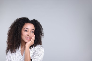 Photo of Beautiful Brazilian woman with healthy skin on gray background. Space for text