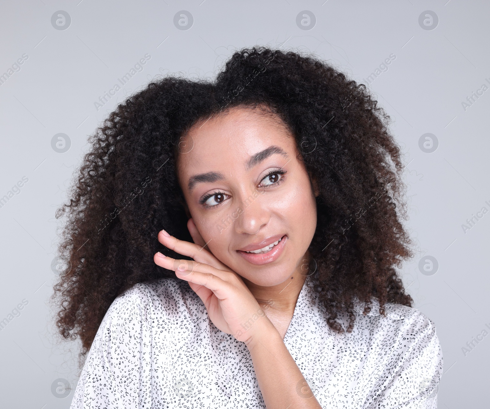 Beautiful Brazilian woman with healthy skin on gray background Photo of Beautiful Brazilian woman with healthy skin on gray background