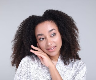 Photo of Beautiful Brazilian woman with healthy skin on gray background