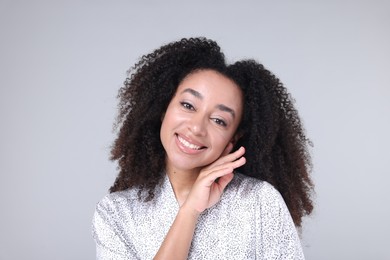 Photo of Beautiful Brazilian woman with healthy skin on gray background