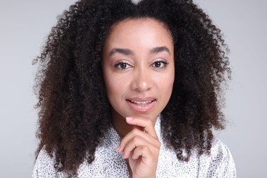 Photo of Beautiful Brazilian woman with healthy skin on gray background, closeup