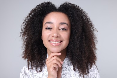 Photo of Beautiful Brazilian woman with healthy skin on gray background