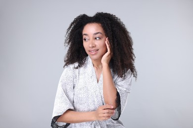 Photo of Beautiful Brazilian woman with healthy skin on gray background