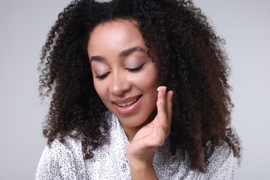 Photo of Beautiful Brazilian woman with collagen cream on gray background