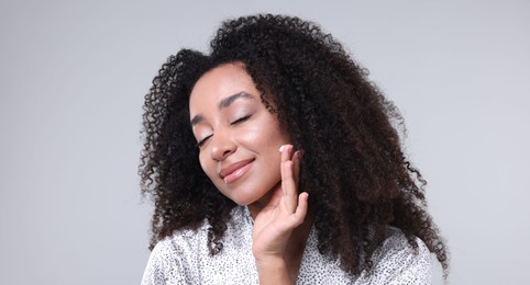 Photo of Beautiful Brazilian woman with collagen cream on gray background