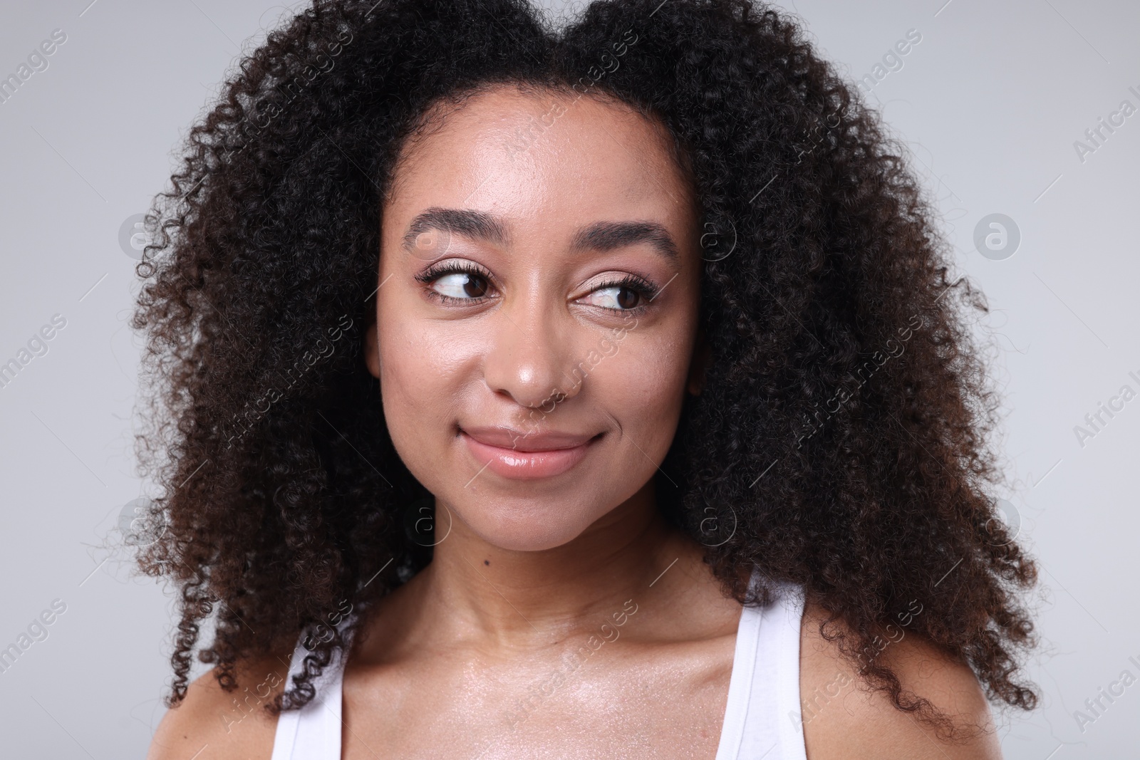 Beautiful Brazilian woman with healthy skin on gray background, closeup Photo of Beautiful Brazilian woman with healthy skin on gray background, closeup
