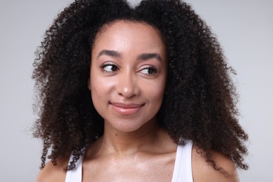 Photo of Beautiful Brazilian woman with healthy skin on gray background, closeup