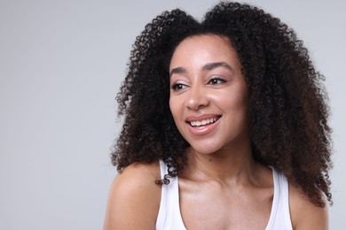 Photo of Beautiful Brazilian woman with healthy skin on gray background. Space for text