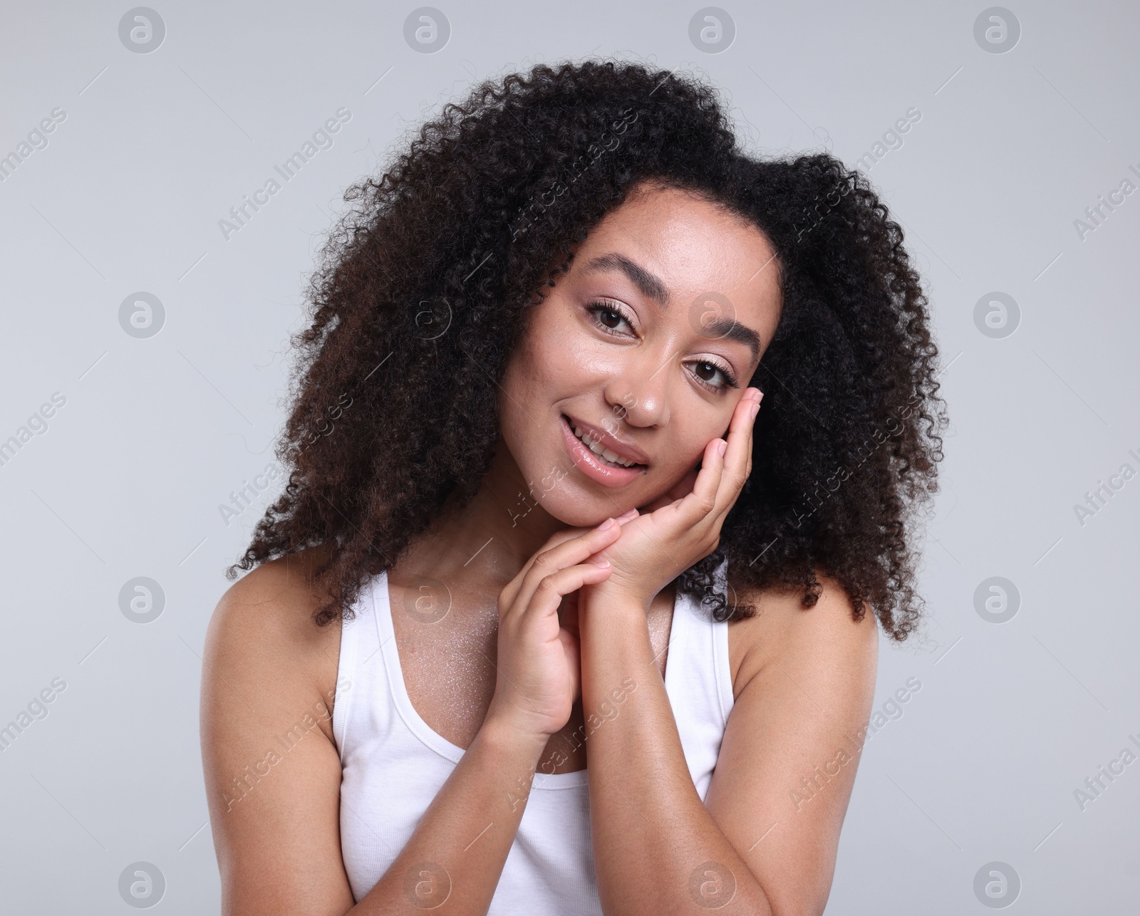 Beautiful Brazilian woman with healthy skin on gray background Photo of Beautiful Brazilian woman with healthy skin on gray background