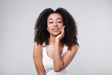 Photo of Beautiful Brazilian woman with healthy skin on gray background