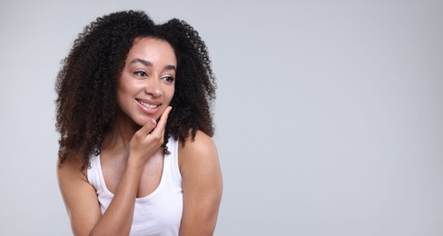 Photo of Beautiful Brazilian woman with healthy skin on gray background. Space for text