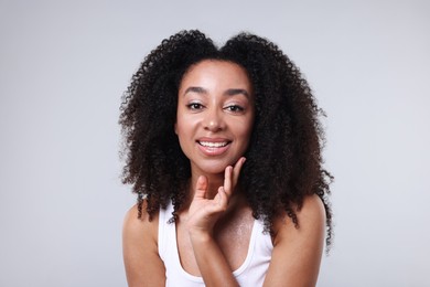 Photo of Beautiful Brazilian woman with healthy skin on gray background