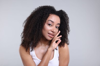 Photo of Beautiful Brazilian woman with healthy skin on gray background