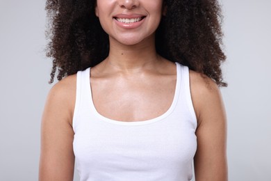 Photo of Brazilian woman with healthy skin on gray background, closeup