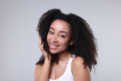 Photo of Beautiful Brazilian woman with healthy skin on gray background