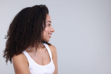 Photo of Beautiful Brazilian woman with healthy skin on gray background. Space for text