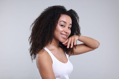 Photo of Beautiful Brazilian woman with healthy skin on gray background