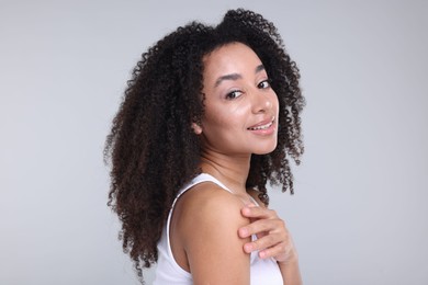 Photo of Beautiful Brazilian woman with healthy skin on gray background